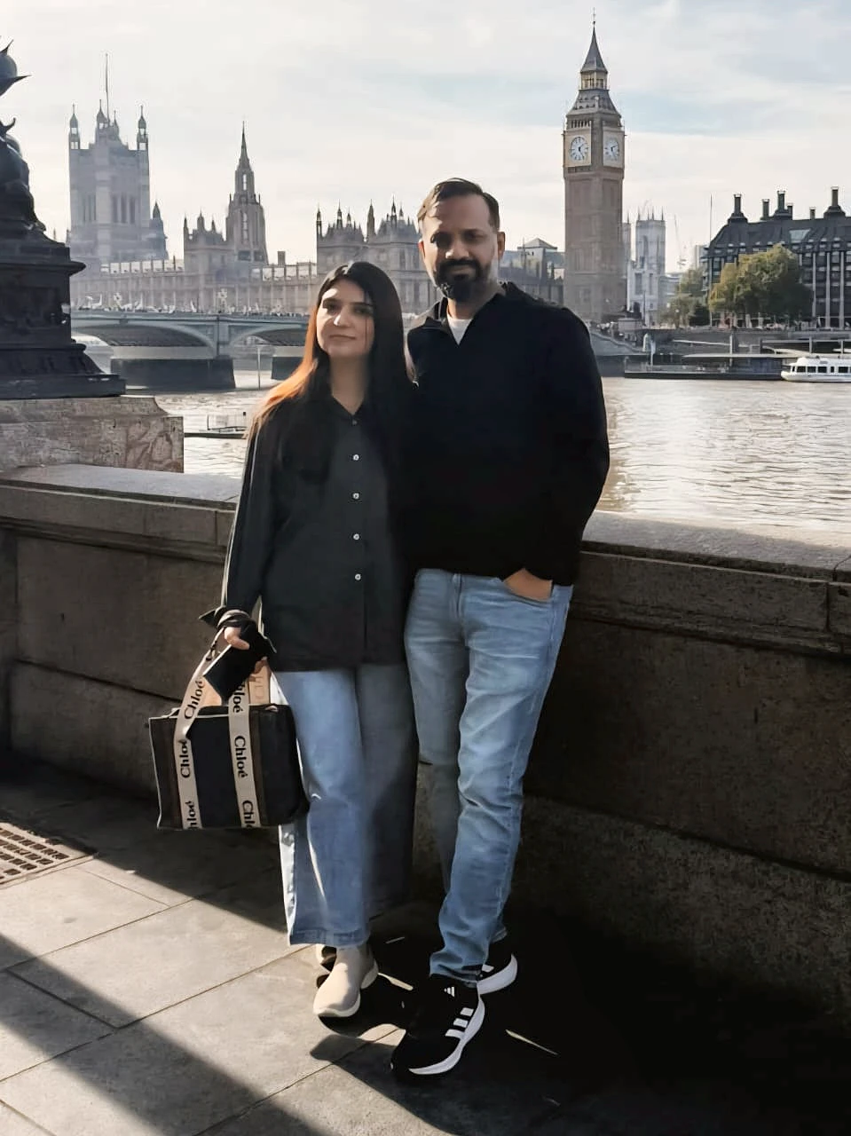 Arwa and her husband by the Thames with Big Ben and the Houses of Parliament behind them.